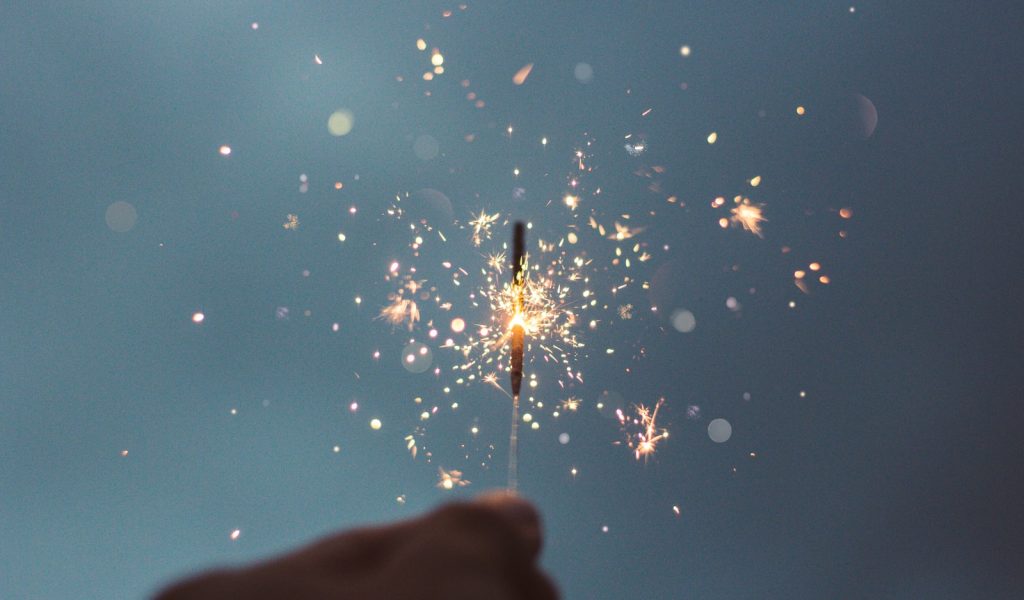 person holding lighted sparklers